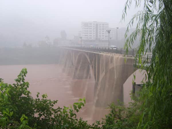 Dated bridge or water-control structure above brown water in Bazhou