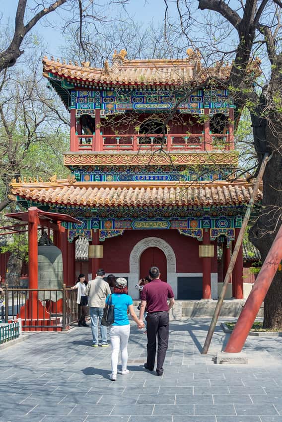 Tree-lined courtyard approach with visitors at Yonghe Temple