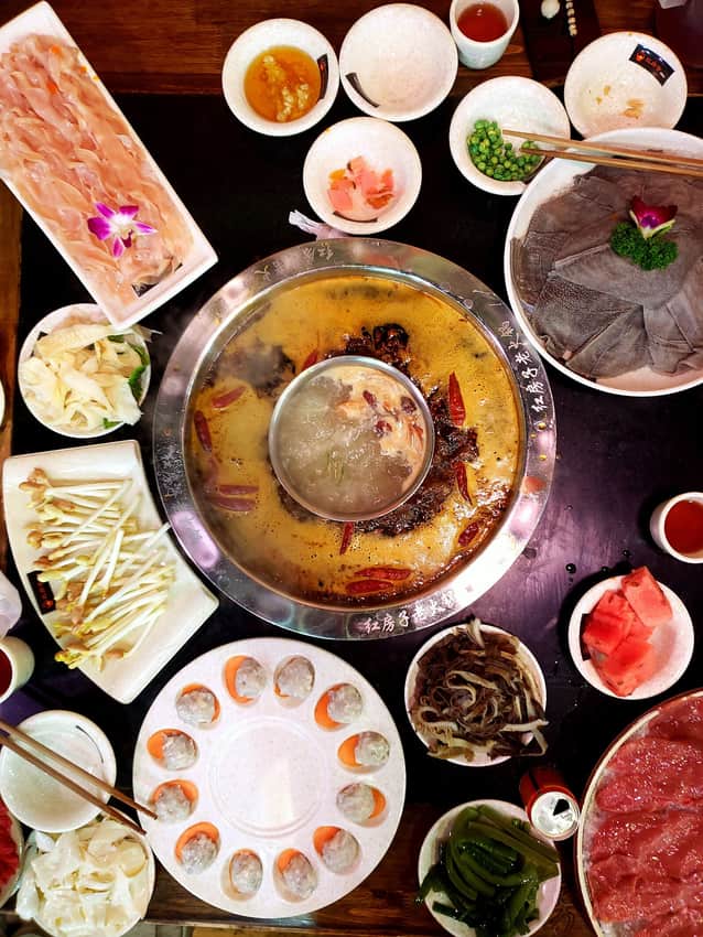 Chongqing hotpot table with one pot and surrounding ingredients