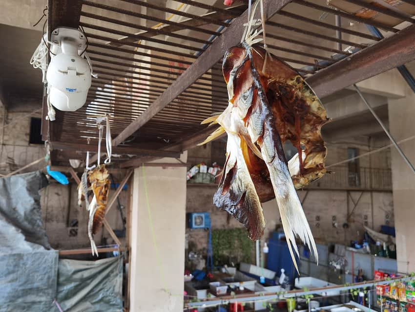 Split preserved fish hanging above a Dazhou market interior