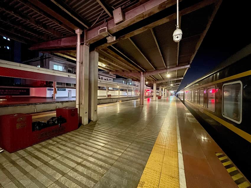 Passenger train beside a wet platform at Dazhou station