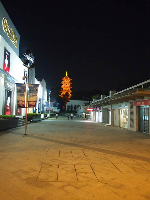 Illuminated Black Pagoda beyond a modern shopping street in 2011