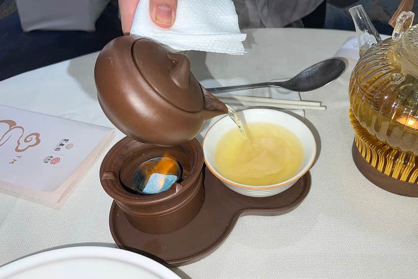 Restaurant presentation of broth being poured for a chicken-broth surf-clam dish in 2025