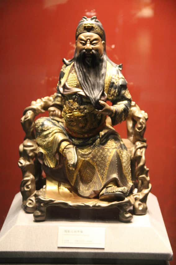 Museum display of a seated figure documented as Fuzhou lacquer art