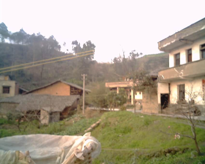 Dated village courtyard and cultivated slope in Huaying