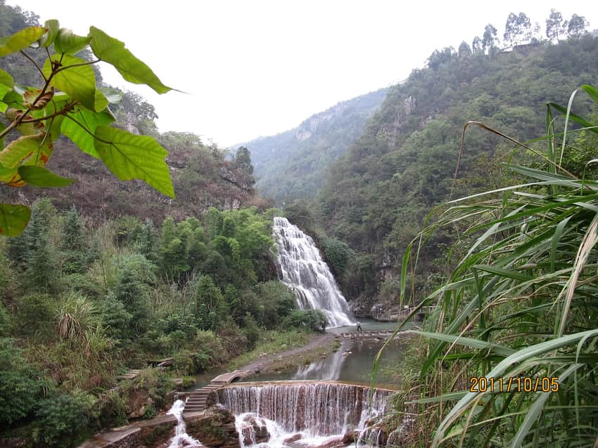 Dated forest waterfall and managed stream in Linshui