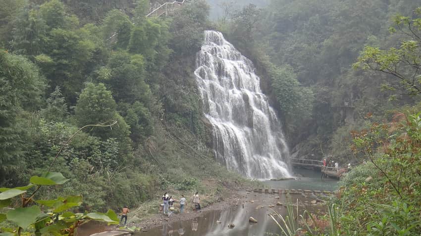 Forest waterfall and visitor path documented in Linshui County