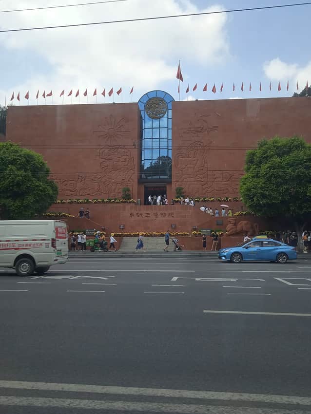 Red museum facade above a busy Guangzhou street