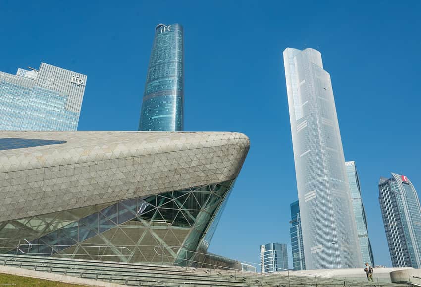 Faceted opera-house volume beneath Zhujiang New Town towers