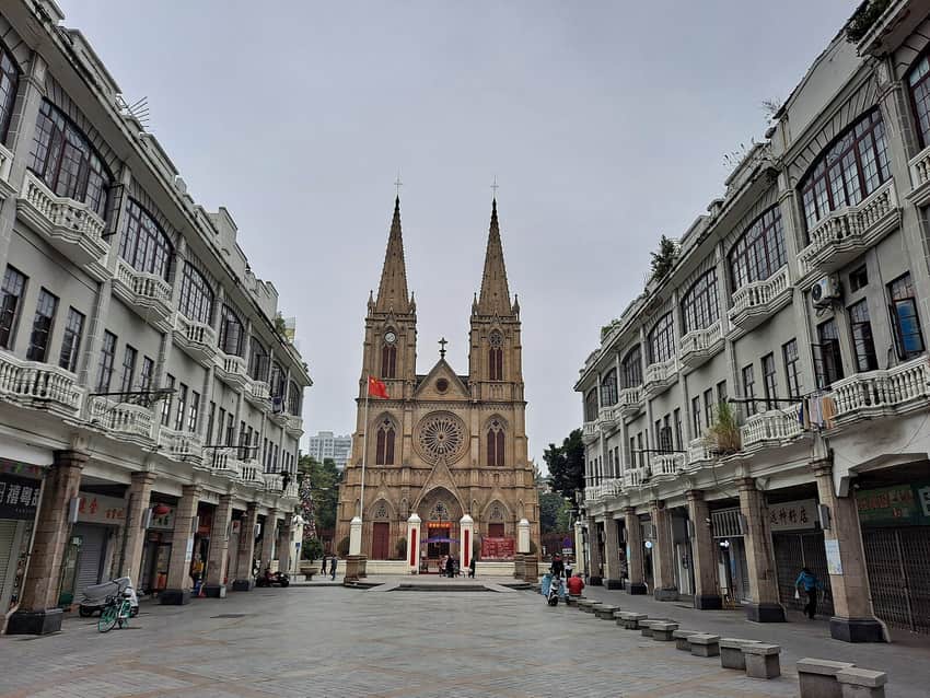 Twin-spired stone cathedral at the end of a Guangzhou street