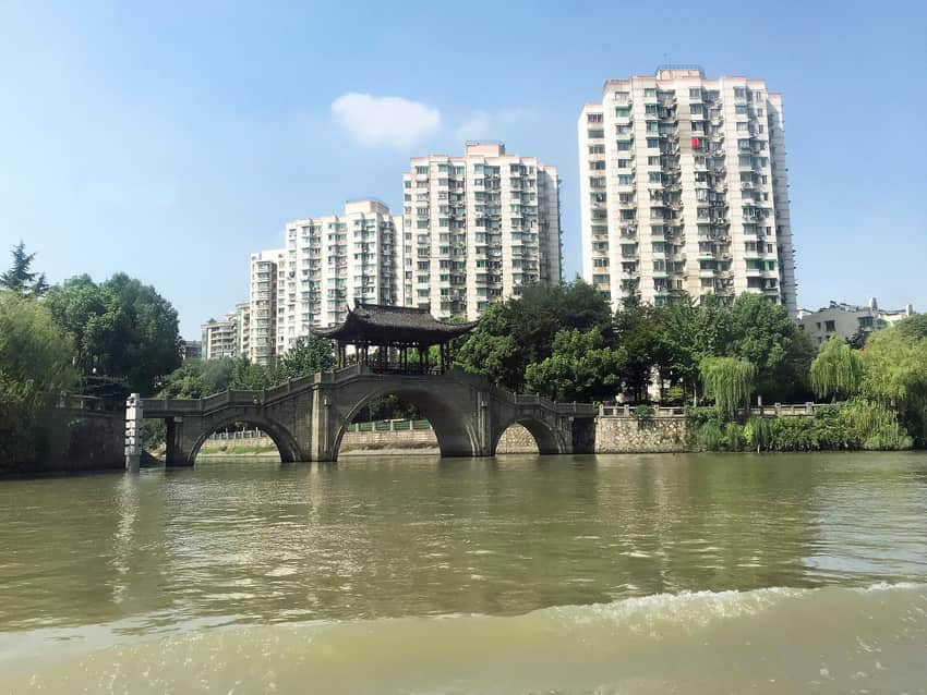 Grand Canal waterway, boats, bridge and later urban buildings in Hangzhou