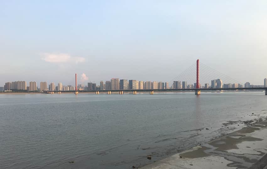 Broad Qiantang River, bridge and urban skyline in daylight