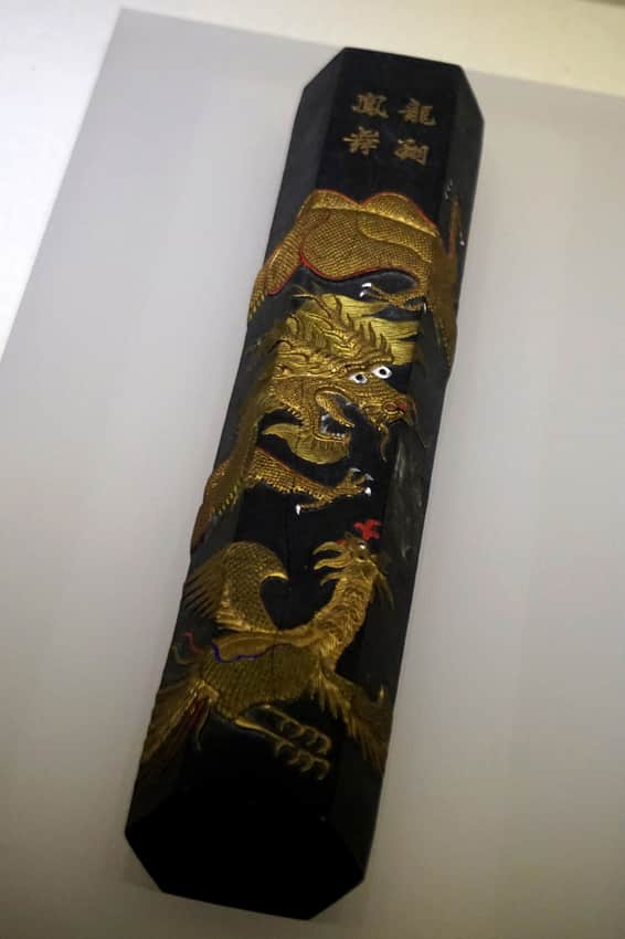 Black decorated inkstick displayed in a museum