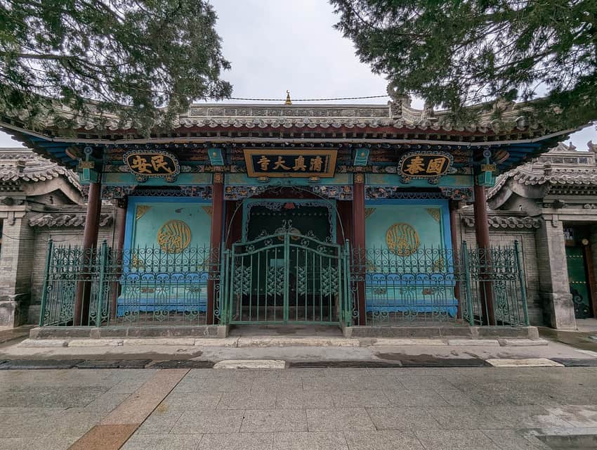 Green-and-teal front gate, plaques and fence at Hohhot Great Mosque in 2025