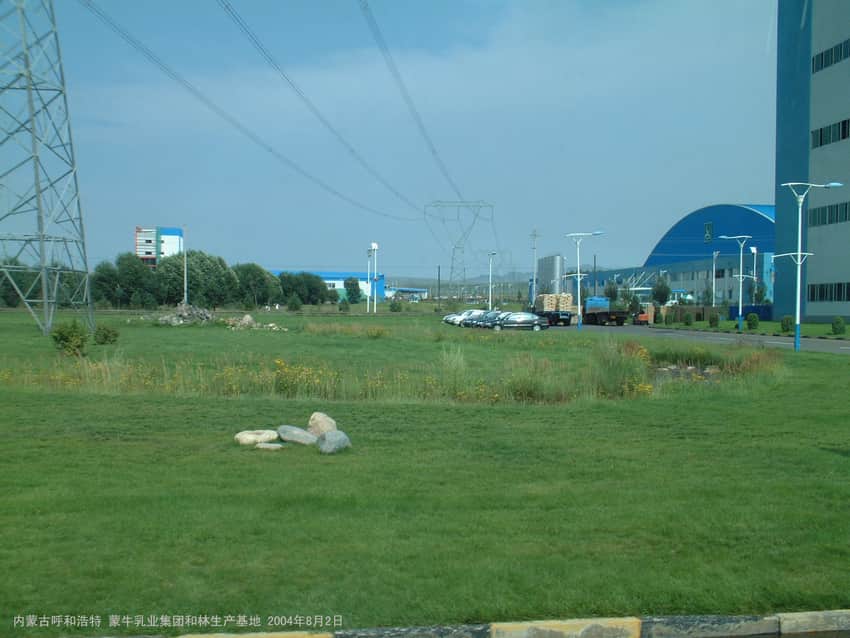 Dated 2004 exterior of a dairy production base in Horinger with buildings and vehicles