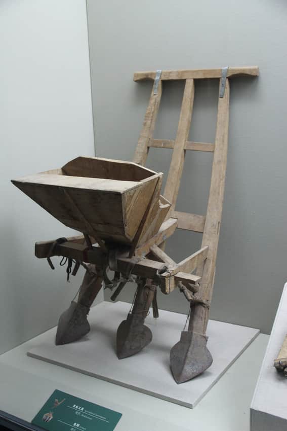 Wooden Daur plough and seed planter with iron parts in a museum display