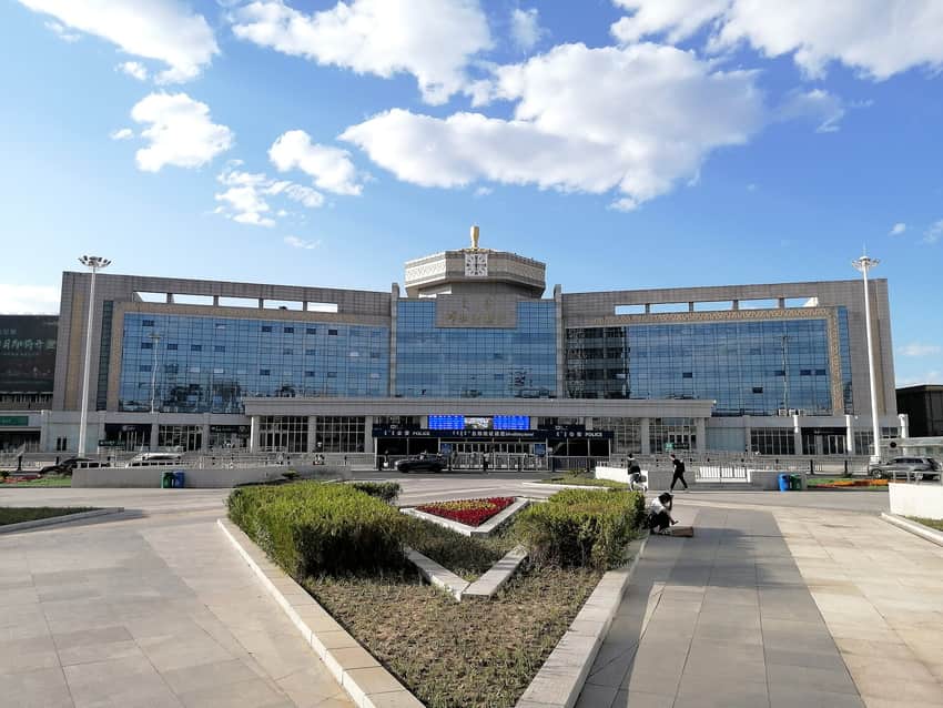 Hohhot Railway Station facade, clock, multilingual sign and landscaped forecourt in 2023