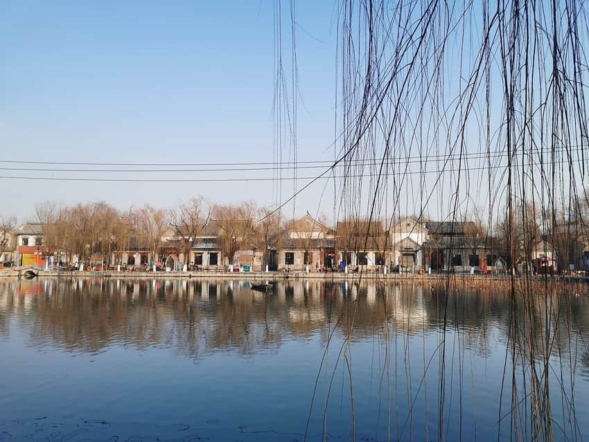 Baihuazhou waterside with willow trees and low buildings
