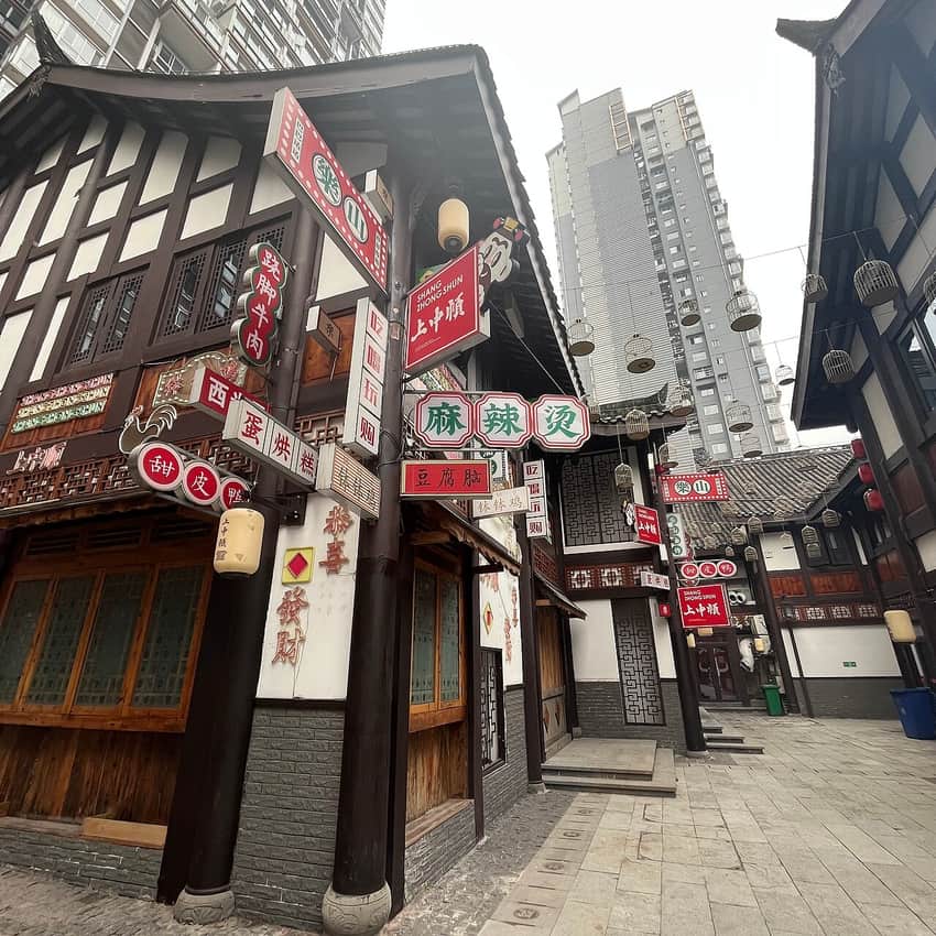 Leshan food street with dense restaurant signs and modern towers