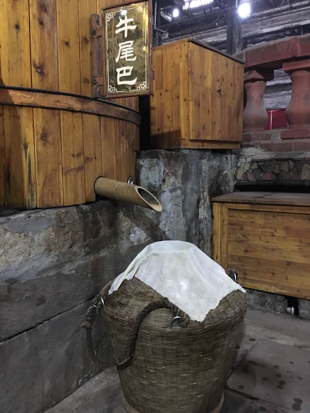 Workers handling grain during baijiu production in Luzhou