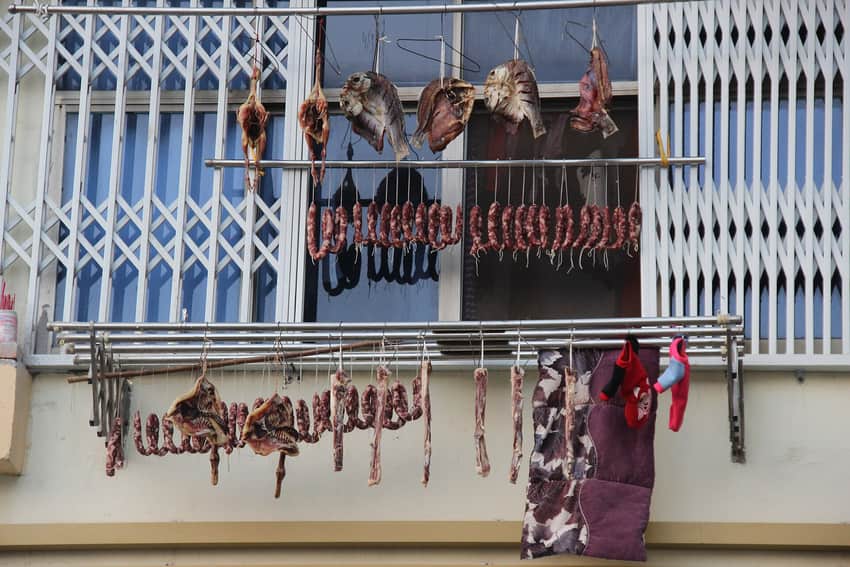 Dated household meat-curing scene at an apartment window in Nanchang