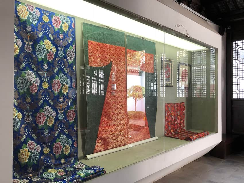 Patterned Nanjing Yunjin textiles behind glass in a museum
