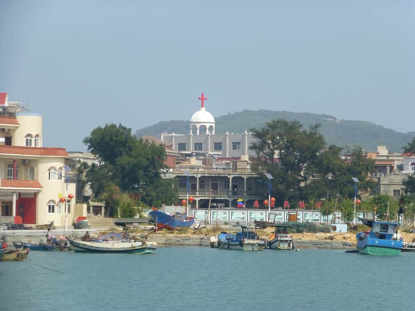 Small boats, waterfront work, housing and church in a Chongwu harbor settlement