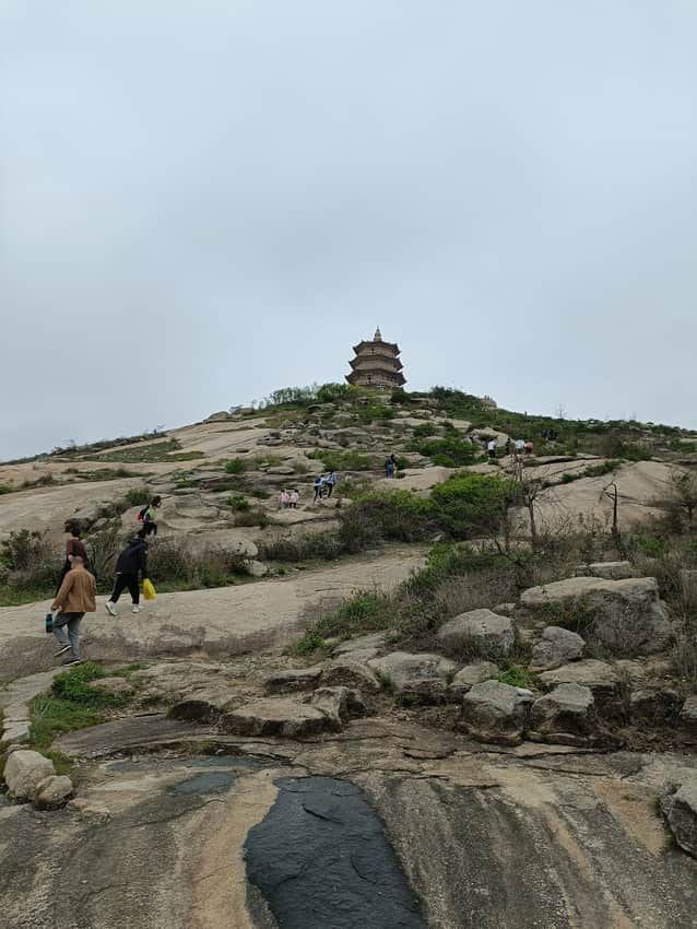 Distant Wanshou Pagoda above a rocky hill with visitors