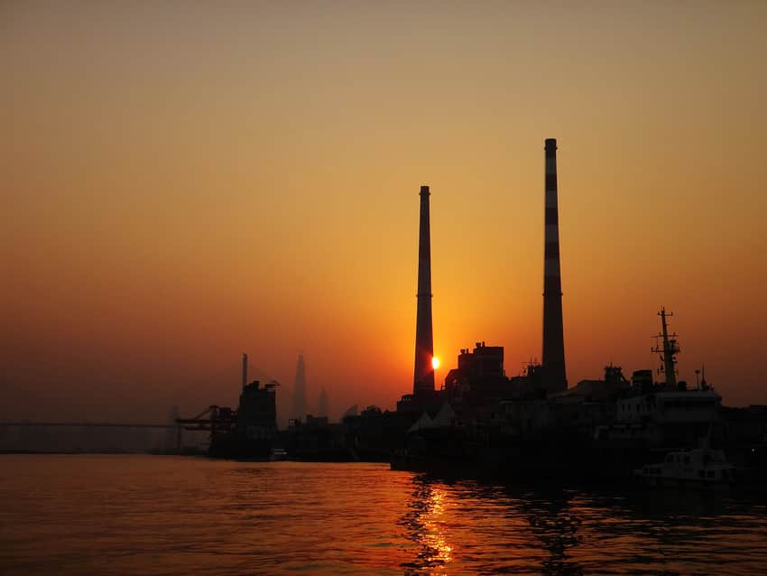 Sunset silhouette of Yangshupu Power Plant and moored vessels across the river
