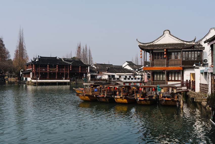 Canal in Zhujiajiao lined with white-walled buildings and moored boats