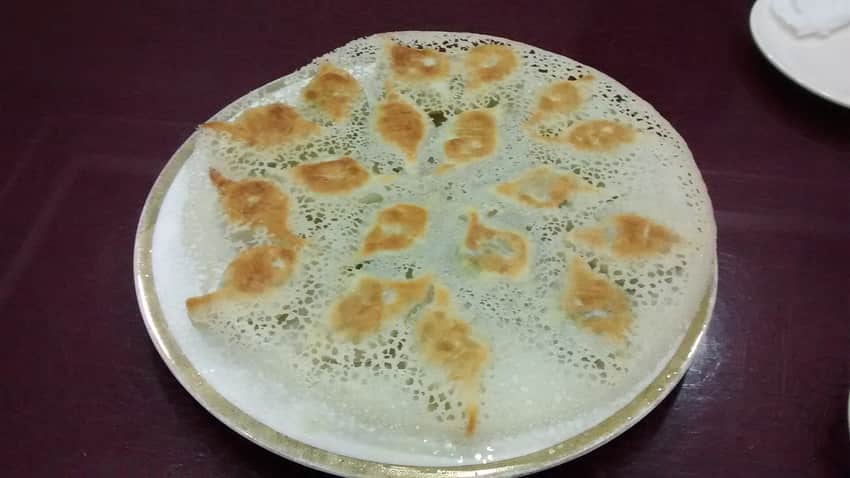 Pan-fried dumplings connected by a thin crisp starch lattice