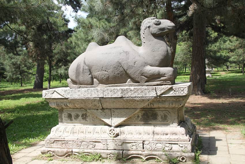 Stone camel and carved pedestal among pines at Fuling