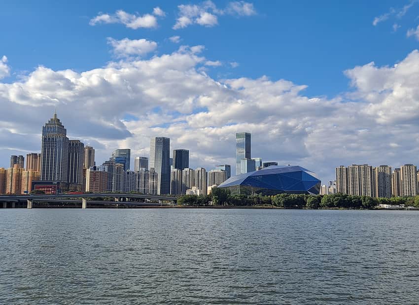 Hun River, green banks and modern Shenyang skyline under clear skies