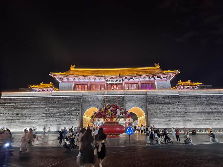 Reconstructed Yanghe Tower with night lighting, crowds and traffic