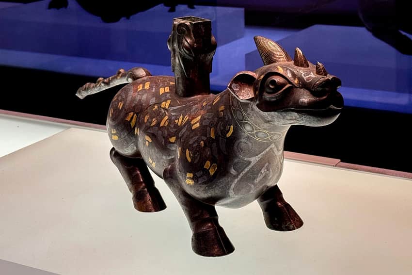 Bronze rhinoceros-form stand with gold-and-silver inlay in a museum display