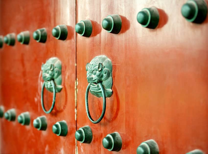Metal bosses and ring handles on a red door at Hanshan Temple