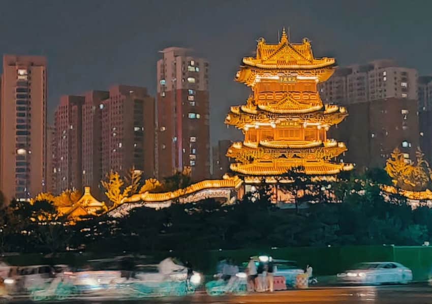 Illuminated traditional-style pavilion, housing towers and traffic in a 2019 Taiyuan night view