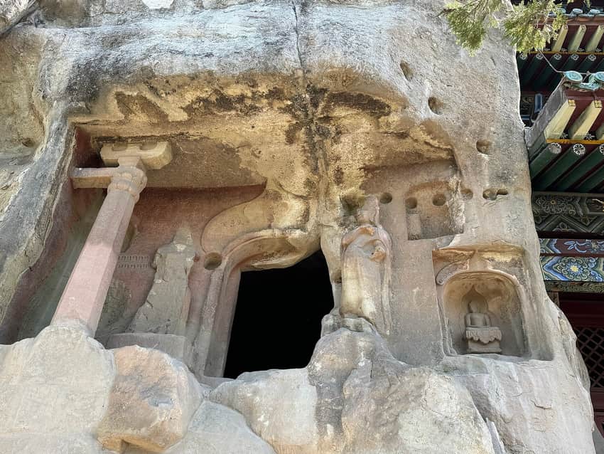 Weathered rock-cut figures, cave opening and later protective eave at Tianlongshan