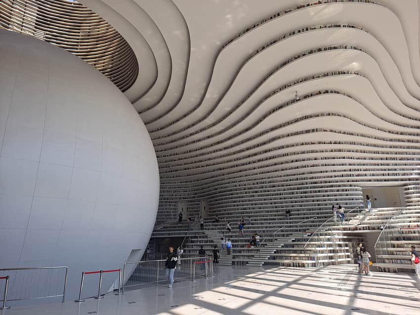 Spherical auditorium, flowing terraces and visitors inside Tianjin Binhai Library
