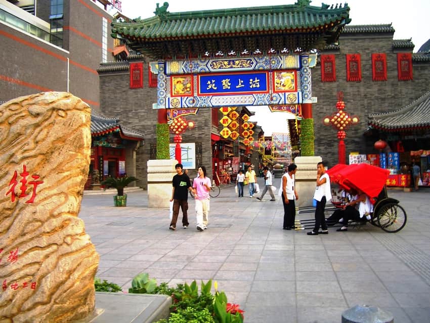 Traditional-style gateway, shops and visitors at Tianjin Ancient Culture Street