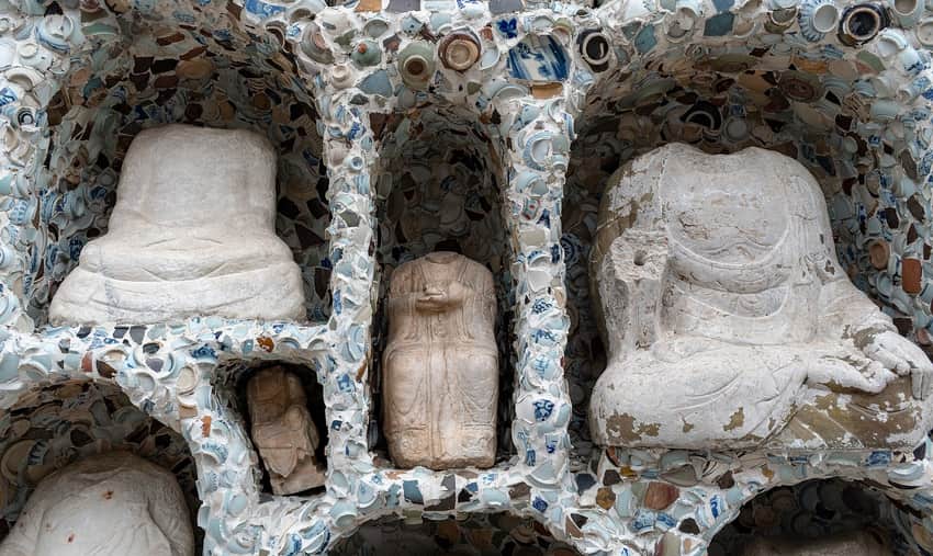 Stone figures in niches and porcelain-shard surface at Tianjin Porcelain House
