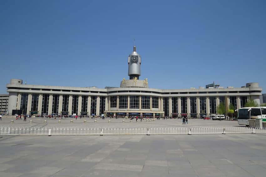 Frontal 2016 view of Tianjin Railway Station, clock tower, plaza and passengers
