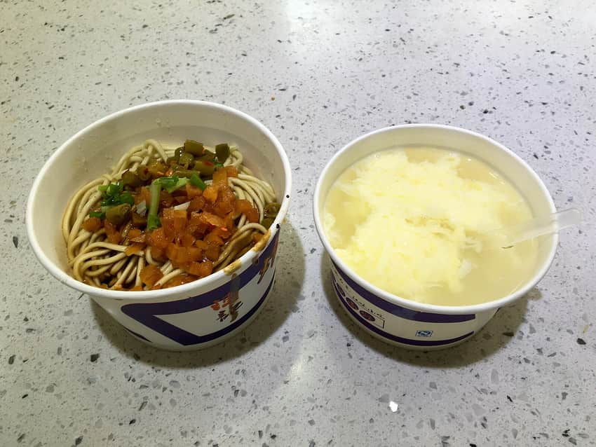 Paper bowls of hot-dry noodles and egg rice wine