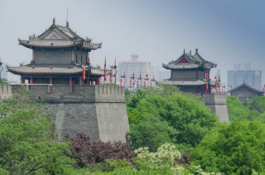 Xi'an wall ramparts and roofed towers behind a green foreground