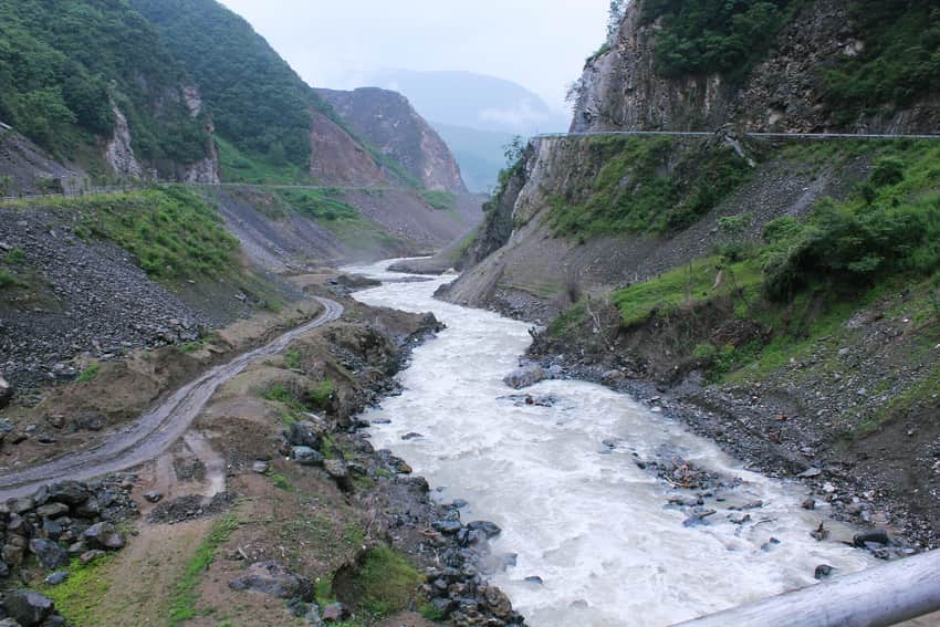 Fast Dong River between steep road-cut slopes in Baoxing