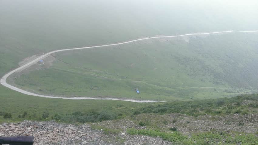 Switchback road across foggy open highland slopes in the Jiajin Mountains