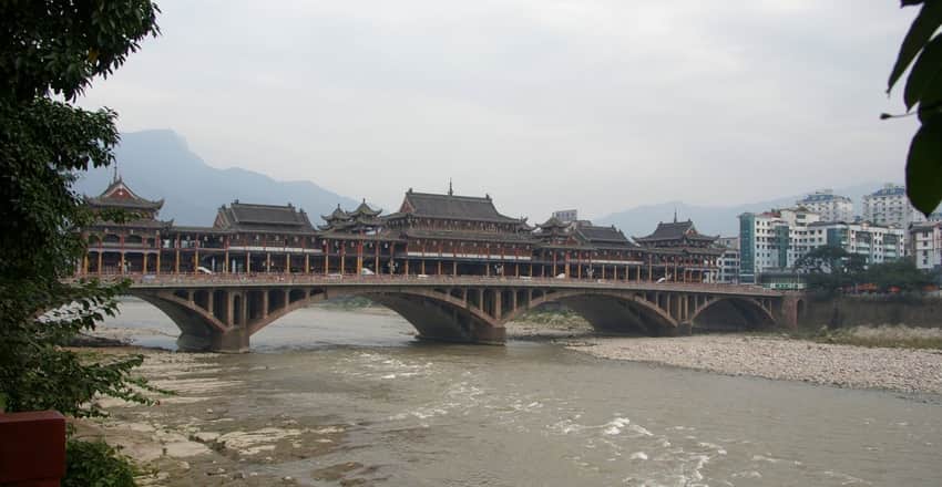 Arched old bridge with traditional-style frontage across the river