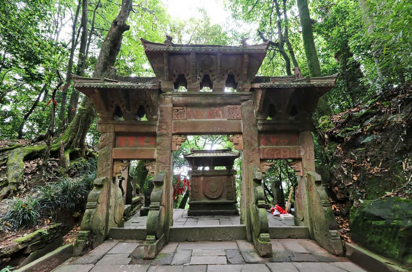 Weathered stone archway in woodland on the Mount Mengding route