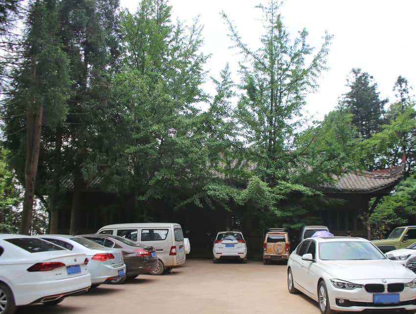 Tree-shaded Yuwang Palace compound behind a working car park