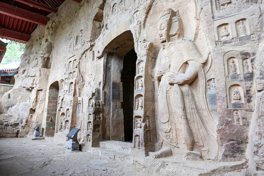 Carved cliff facade, standing figure and niches at Cave 4 of the Gongxian Grottoes
